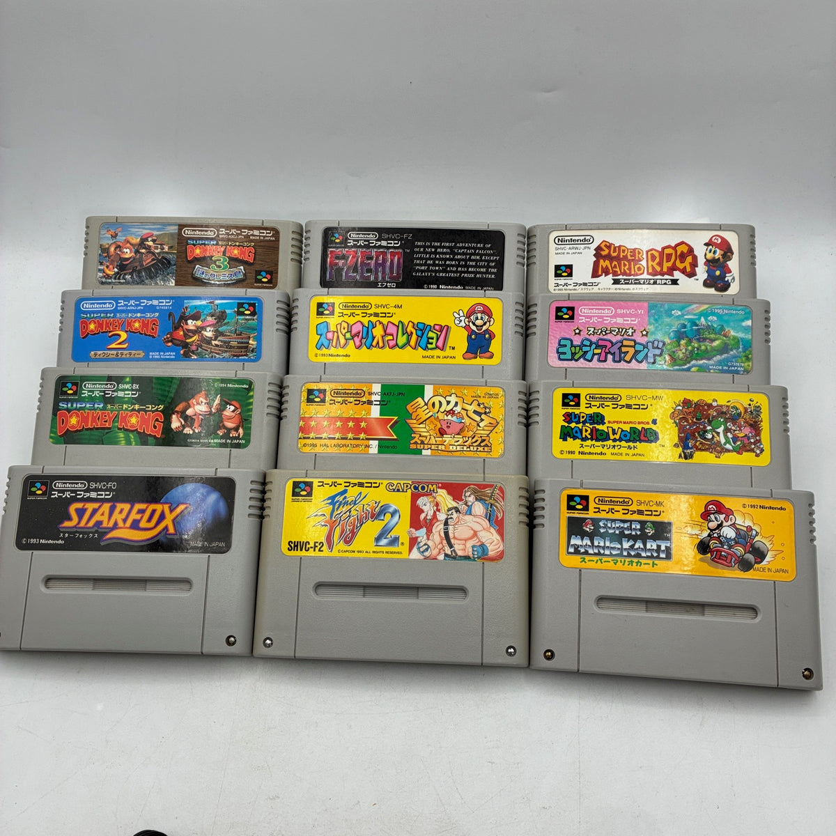 The 12 cartridges of the 12-game set: the 9-game set plus F-Zero, Kirby Super Star and Final Fight 2